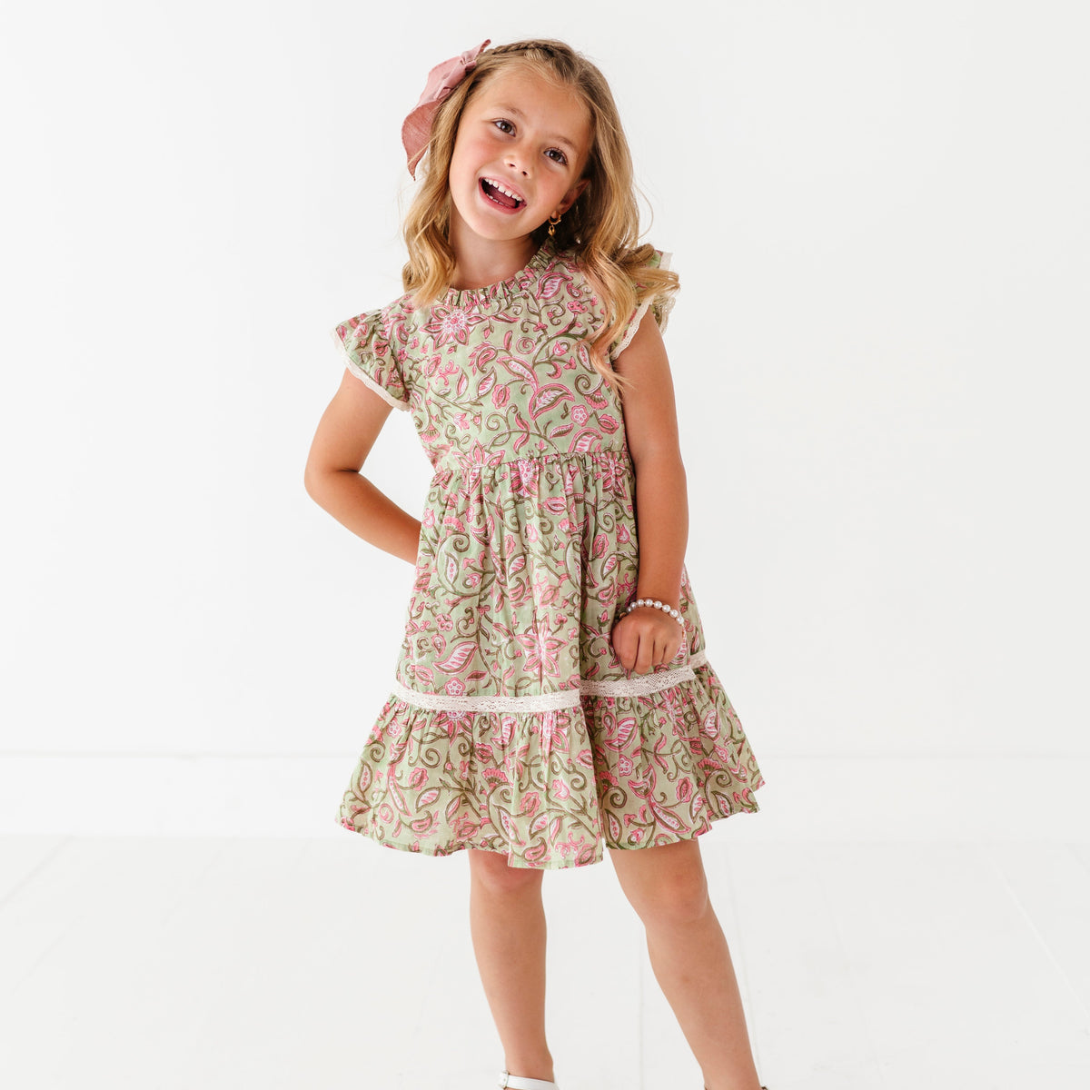 Young girl wearing a floral dress on a white background
