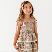 Young girl wearing a floral dress on a white background