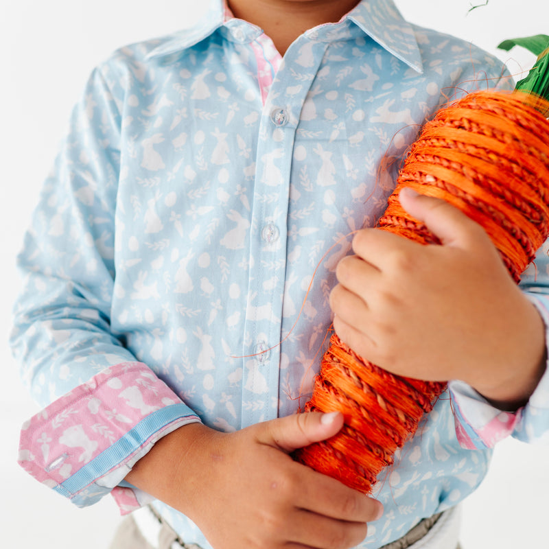 Child holding a large decorative carrot against a white background