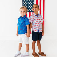Two children standing in front of an American flag