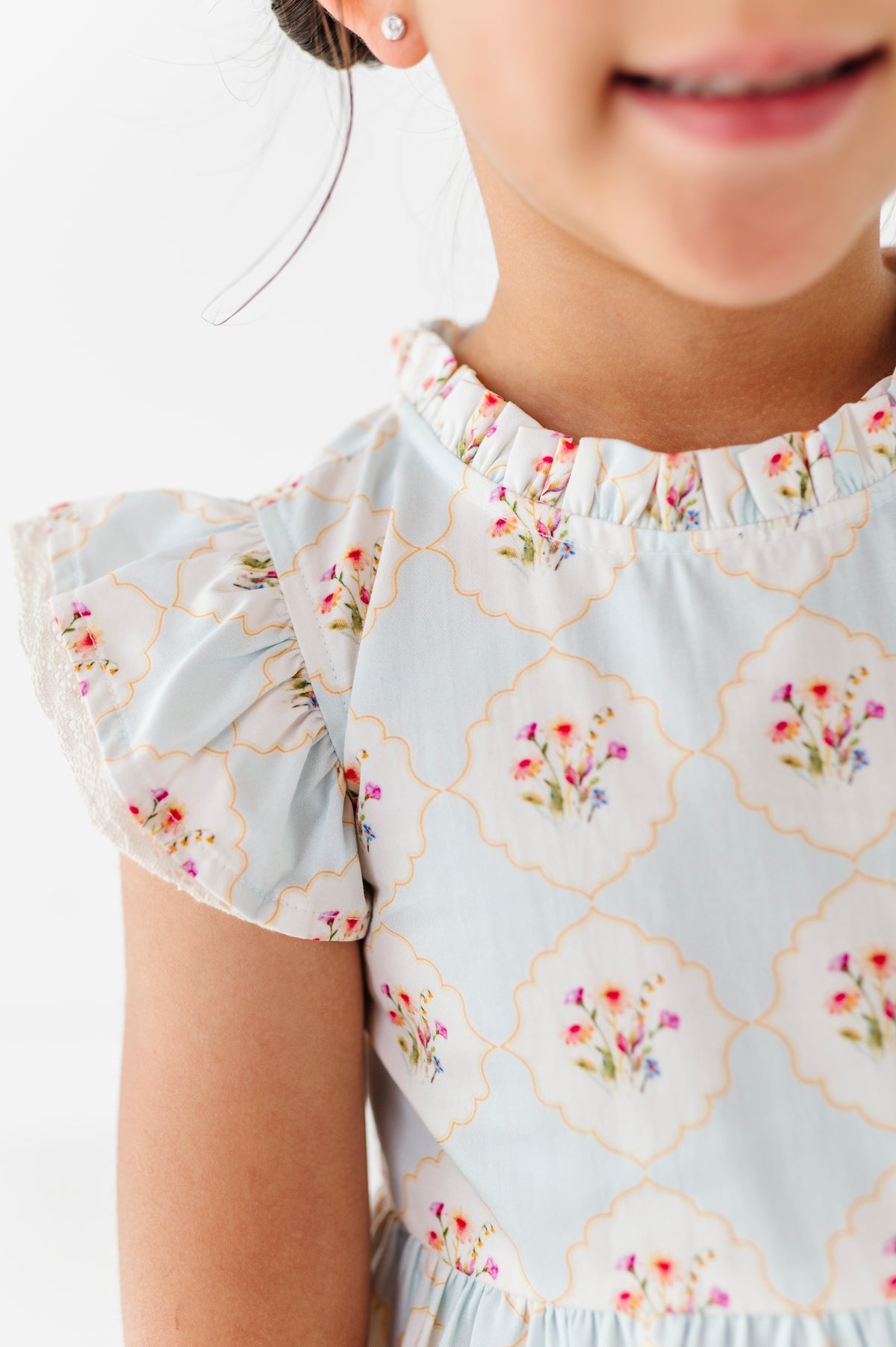 Child wearing a floral dress with a white background