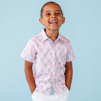 Child wearing a pink lobster shirt against a light blue background