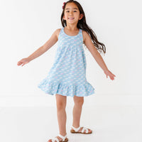 Young girl wearing a light blue dress with white puppies on a white background
