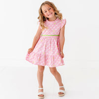 A young girl in a pink dress with a puppy print