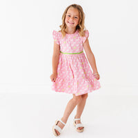 A young girl in a pink dress with a puppy print