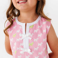 Child wearing a pink dress with puppy pattern and white collar