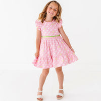 A young girl in a pink dress with a puppy print