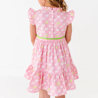 A young girl in a pink dress with a puppy print