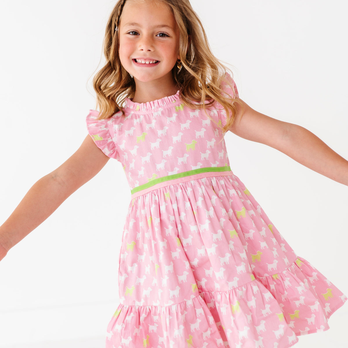 A young girl in a pink dress with a puppy print