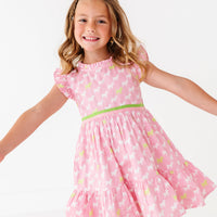 A young girl in a pink dress with a puppy print