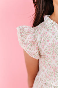 Girl wearing a delicate pink and green floral print  dress 