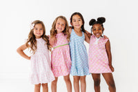 Four young girls wearing colorful dresses on a white background