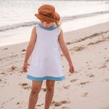 TukTuk Designs girls classic shift dress in cool white with blue trims and side pockets. Perfect for the beach, play dates and everyday.
