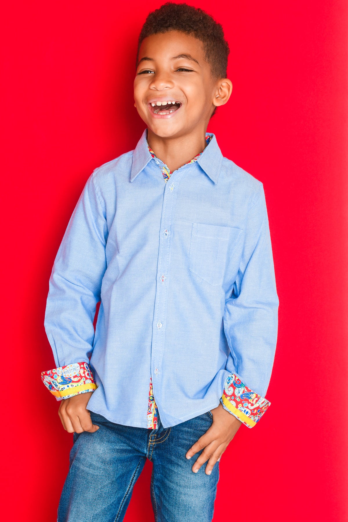 TukTuk Designs long sleeve boys button up chambray, denim blue shirt with colorful contrast trim detail.